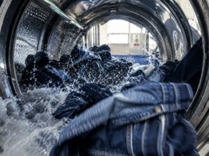 denim garments tumbling inside industrial washing process machine