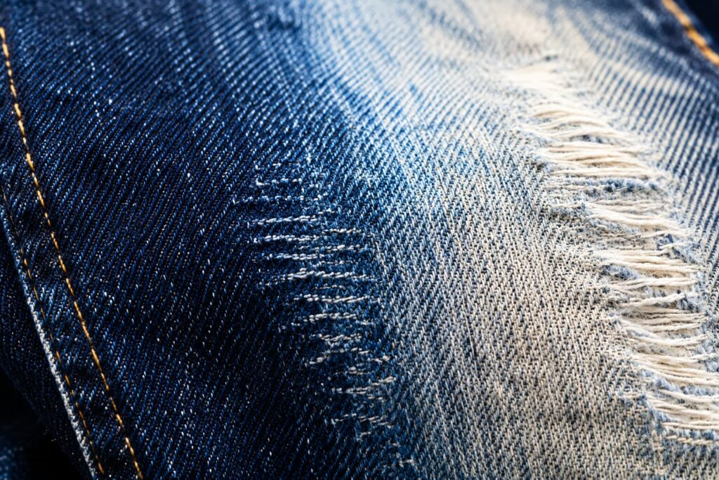 extreme close up of indigo denim fading through wash abrasion